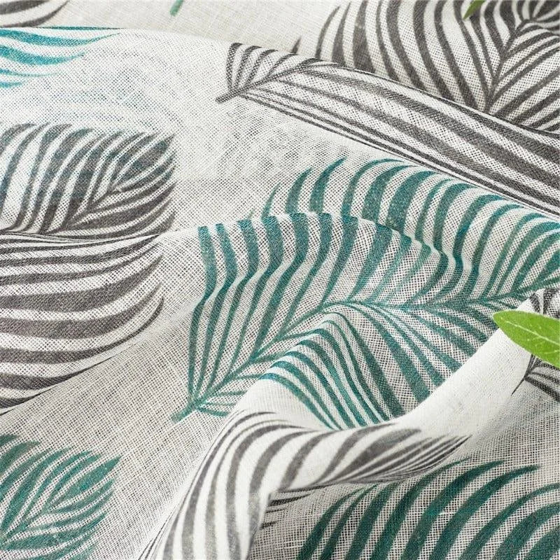 Tissu imprimé au motif de feuilles exotiques vertes et grises sur fond beige, idéal pour la décoration intérieure, rideaux et projets de couture créatifs. Parfait pour apporter une touche naturelle et élégante à votre espace.