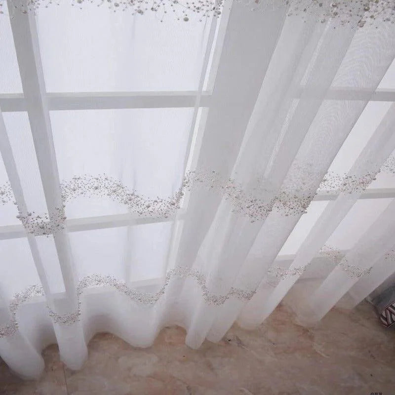 Voilage blanc élégant décoré de petites perles, idéal pour ajouter une touche raffinée à votre intérieur. Rideau lumineux pour fenêtres, parfait pour salons ou chambres modernes. Accessoire chic et décoratif pour embellir vos espaces de vie avec style et légèreté.