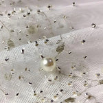 Tissu élégant avec motif perlé et détails scintillants, idéal pour les créations de mode sophistiquées et les décorations raffinées. Parfait pour ajouter une touche de glamour à vos projets couture et événements spéciaux.