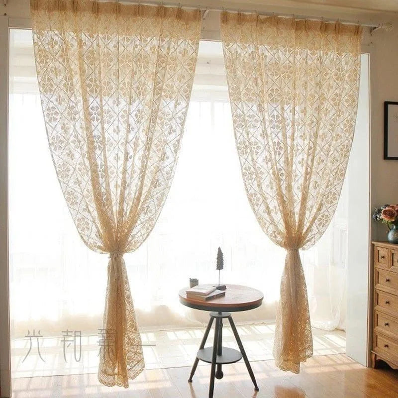 Rideaux en dentelle ornés de motifs géométriques suspendus devant une large baie vitrée, idéale pour illuminer un salon ou une chambre. Ces rideaux élégants ajoutent une touche décorative raffinée, tout en laissant filtrer la lumière naturelle pour créer une ambiance chaleureuse et accueillante.