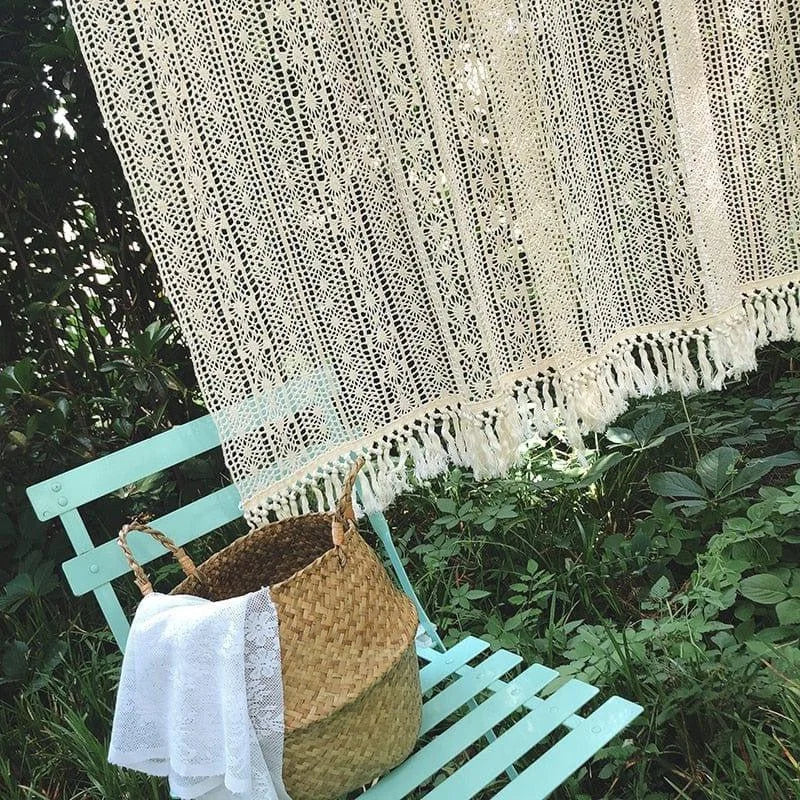 Décoration bohème avec un rideau crocheté élégant, accroché en extérieur. Ambiance naturelle et paisible avec un banc vert pastel et un panier tressé. Idéal pour créer un espace cosy dans votre jardin ou terrasse, apportant une touche d'élégance et de style artisanal à votre décoration extérieure.