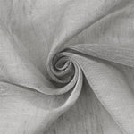 Gros plan sur un tissu gris élégant, enroulé en forme de spirale, idéal pour la confection de rideaux ou de vêtements sur mesure. Ce modèle met en avant une texture raffinée et un aspect moderne, parfait pour tout projet de décoration intérieure chic.