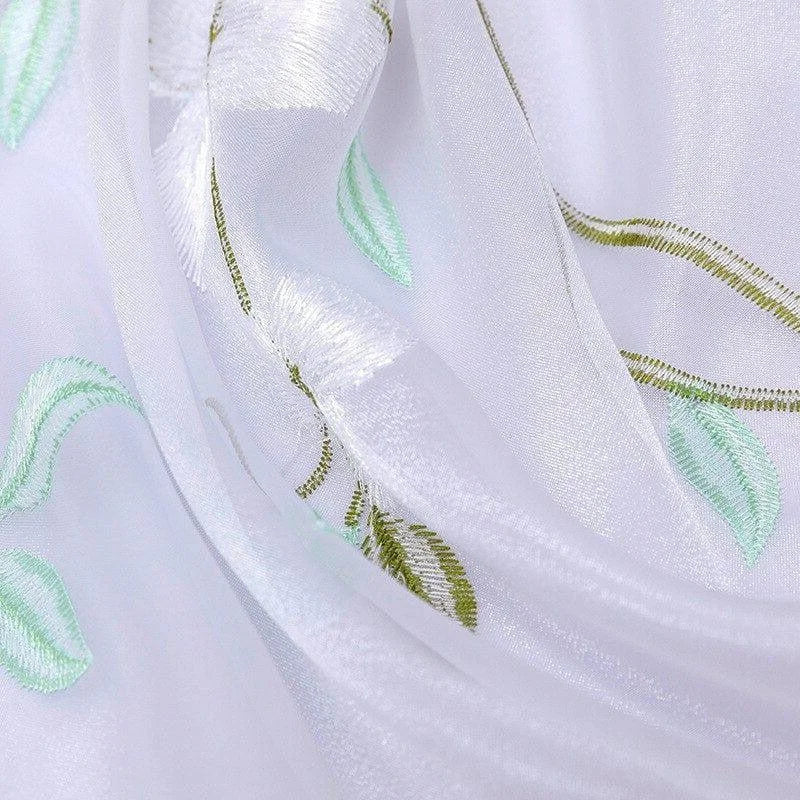 Voilage translucide avec broderies de feuilles vertes, idéal pour apporter une touche élégante et lumineuse à votre intérieur. Design raffiné parfait pour les fenêtres de salon ou chambre à coucher, créant une atmosphère paisible et naturelle. Facile d'entretien et d'installation, ce rideau ajoutera du charme à toutes vos pièces.