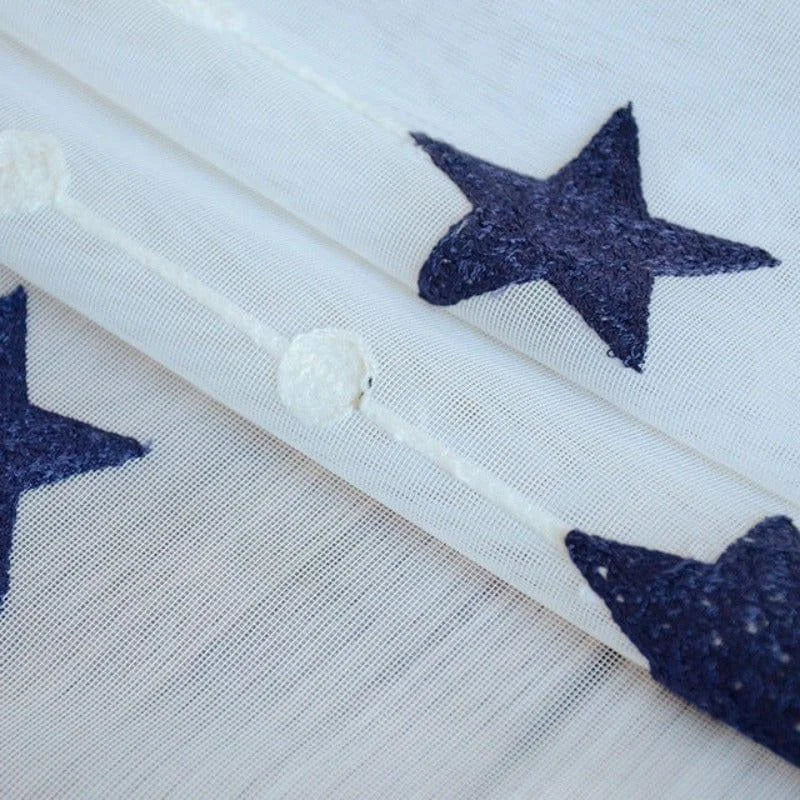 Tissu décoratif blanc avec motifs d'étoiles bleu marine, idéal pour la décoration intérieure. Design moderne et élégant, parfait pour ajouter une touche créative à votre espace de vie. Convient pour la confection de rideaux, nappes ou coussins.