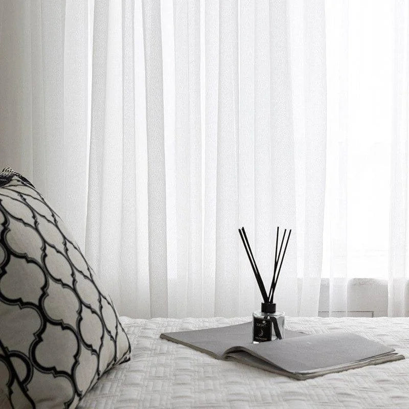 Rideau blanc transparent pour une décoration intérieure moderne et épurée. Évoque une atmosphère relaxante et lumineuse. Idéal pour salon ou chambre à coucher. Accessoire parfait pour créer une ambiance apaisante.