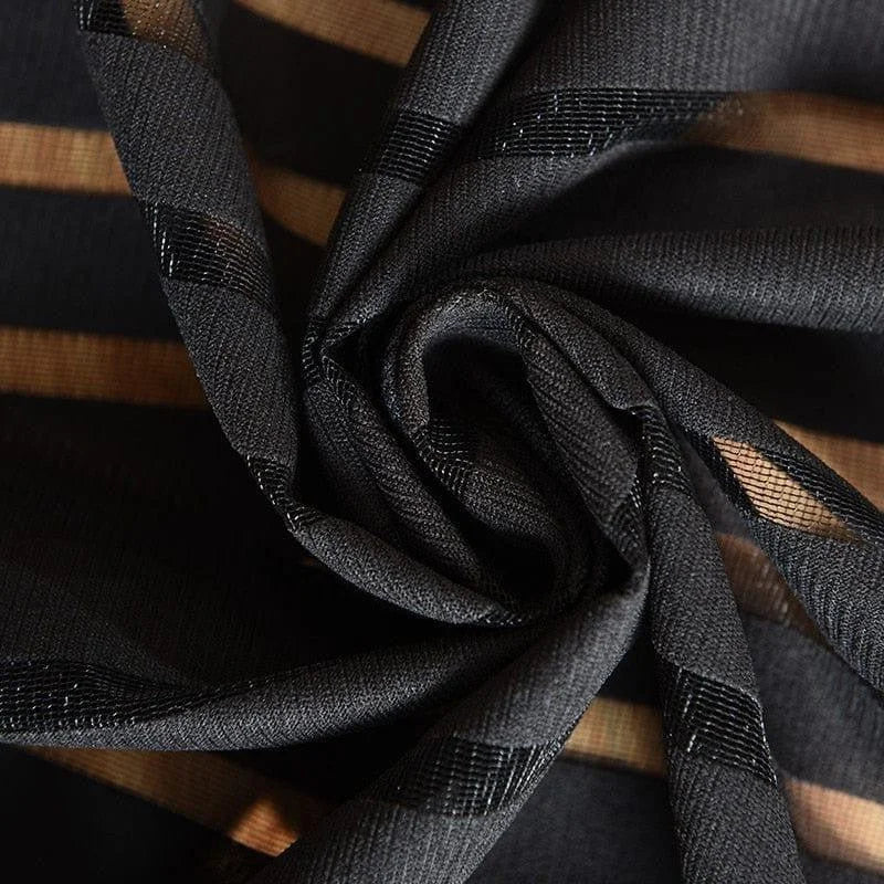 Image gros-plan d'un tissu noir à rayures transparentes, idéal pour la confection de vêtements élégants et modernes. Ce textile est parfait pour créer des effets de superposition raffinés et ajoutera une touche de sophistication à vos créations vestimentaires.
