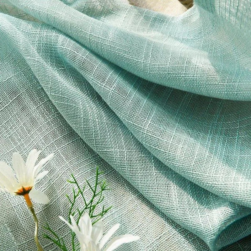 Tissu aux teintes pastel bleu clair, idéal pour la décoration intérieure, apporte une touche élégante et rafraîchissante aux espaces de vie. Fleurs blanches délicates en arrière-plan pour une ambiance naturelle et apaisante.
