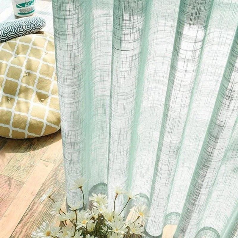 Rideau translucide vert doux pour une décoration intérieure élégante et lumineuse. Accessoire parfait pour filtrer la lumière tout en ajoutant une touche de fraîcheur à votre espace. Idéal pour un salon, une chambre ou une salle à manger, ce rideau transforme l'ambiance avec raffinement. Notez les coussins décoratifs en arrière-plan qui complètent l'esthétique générale.