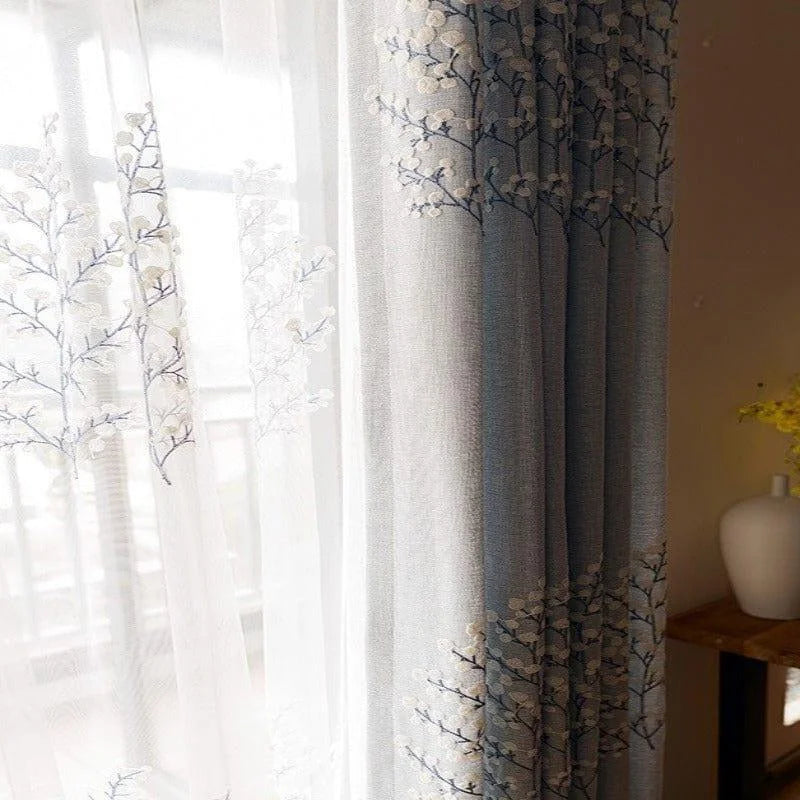 Rideaux élégants bleus et blancs avec motif floral, parfaits pour apporter une touche décorative raffinée à votre intérieur. Idéals pour filtrer la lumière tout en embellissant votre salon ou chambre à coucher grâce à leurs motifs délicats.
