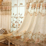 Rideau floral vintage beige partiellement ouvert, laissant entrevoir un second voilage brodé derrière, ambiance romantique.