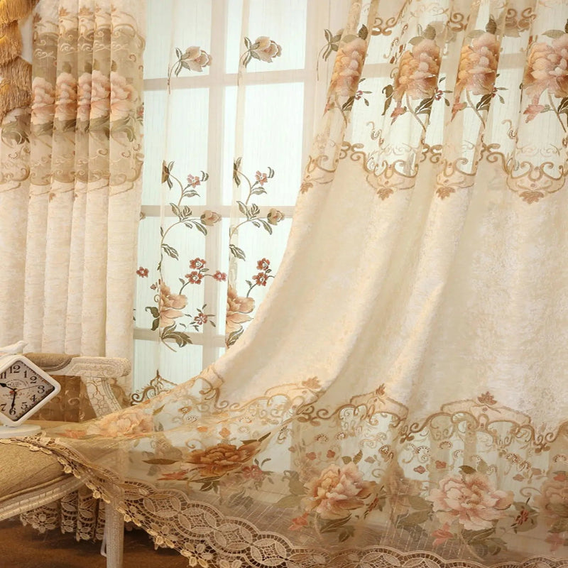 Rideau floral vintage beige partiellement ouvert, laissant entrevoir un second voilage brodé derrière, ambiance romantique.
