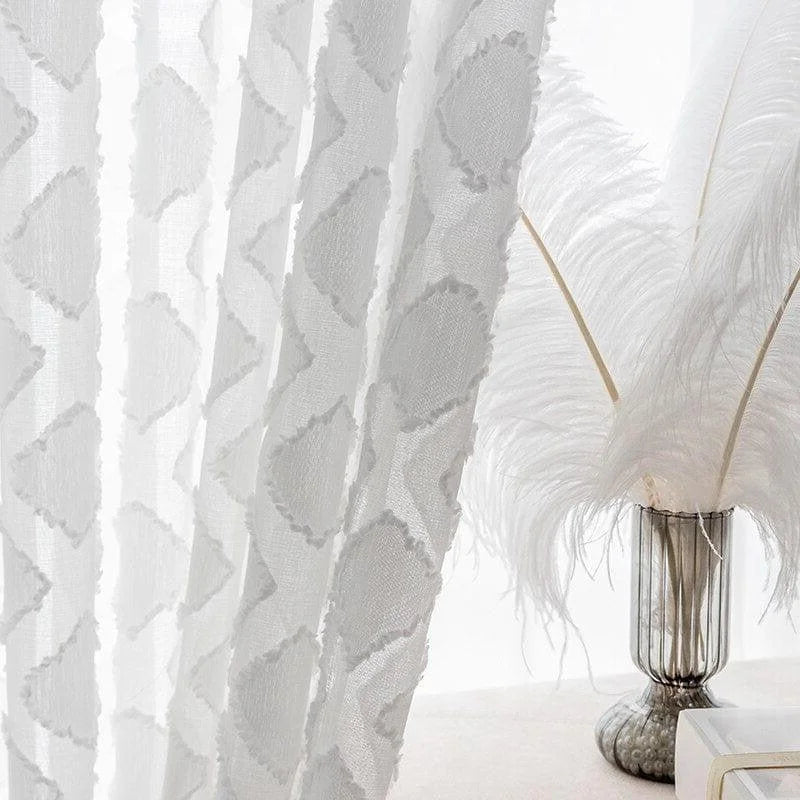 Rideaux blancs élégants avec motifs géométriques, parfaits pour ajouter une touche sophistiquée à votre intérieur. Placés à côté d'un élégant vase décoratif avec des plumes, ces rideaux modernes sont idéals pour la décoration du salon ou de la chambre à coucher, offrant une ambiance lumineuse et aérée.