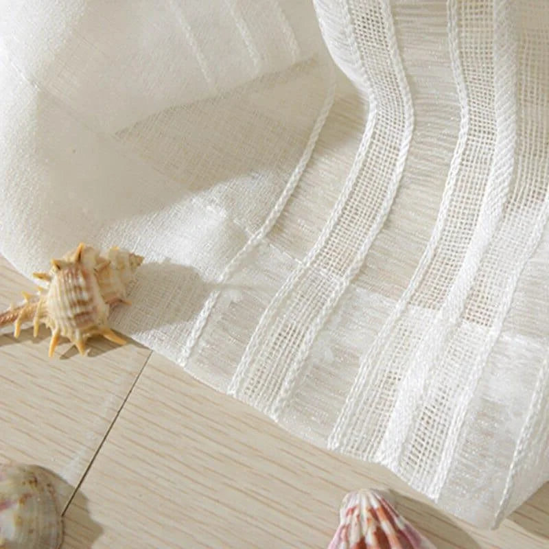 Rideaux élégants blancs avec coquillages décoratifs sur fond en bois clair, apportant une ambiance lumineuse et naturelle à votre intérieur. Parfait pour ajouter une touche de fraîcheur et de sérénité à vos espaces de vie.