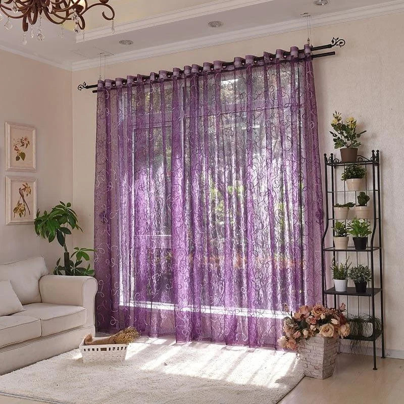Rideaux élégants et modernes de couleur violette ornant un salon lumineux avec canapé blanc, plantes vertes, et un tapis douillet, parfaits pour ajouter une touche de sophistication et d'intimité à votre espace intérieur.