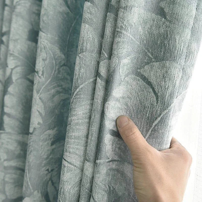 Rideau élégant gris avec motifs floraux artistiques, idéal pour sublimer votre intérieur. Ce rideau ajoute une touche de raffinement, parfait pour un salon ou une chambre, offrant une ambiance apaisante et chic. Prise en main montrant la qualité et le style du design.