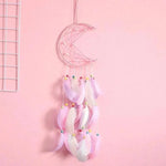 Attrape-rêves en forme de croissant de lune avec plumes et perles colorées, décoration murale tendance pour chambre d'enfant ou chambre à coucher. Ambiance douce et apaisante grâce à ses teintes pastel, idéal pour favoriser des nuits paisibles.