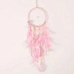 Attrape-rêves rose délicat, parfait pour une décoration de chambre inspirante. Ce capteur de rêves avec ses plumes et perles crée une ambiance apaisante et élégante, idéal pour un ajout boho chic à votre intérieur. Accessoire décoratif tendance pour embellir les murs tout en apportant une touche douce et rêveuse.
