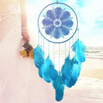 Attrape-rêves bleu avec plumes suspendu en bord de mer, idéal pour une décoration bohème chic. Accessoire parfait pour apporter une touche de couleur apaisante à tout espace intérieur. Objet décoratif tendance pour chambre à coucher ou salon.