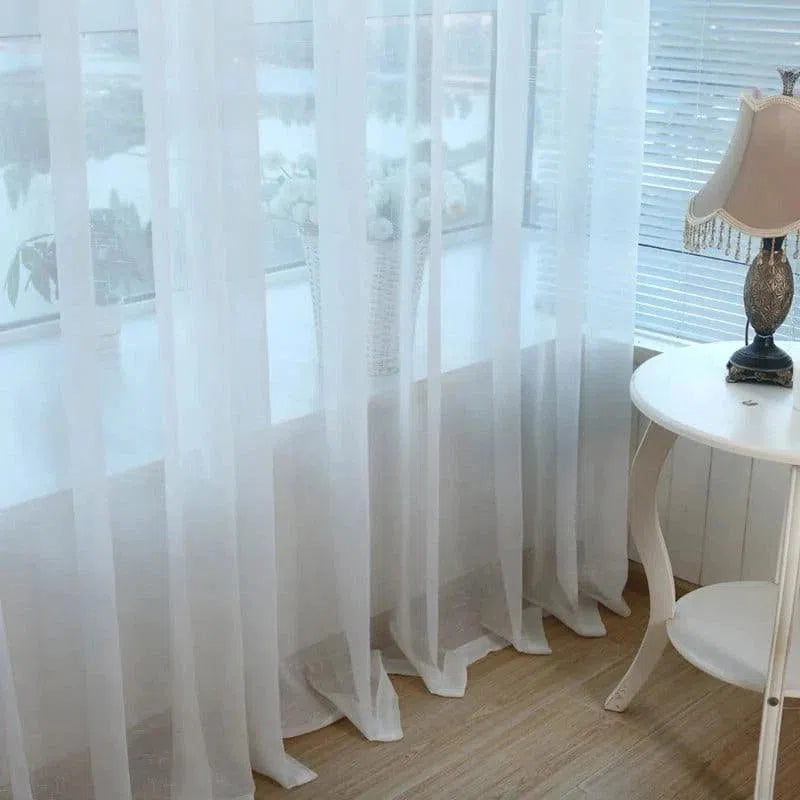Voilage blanc élégant, parfait pour ajouter une touche de sophistication à votre intérieur. Idéal pour filtrer la lumière tout en préservant l'intimité, ce rideau est une solution esthétique pour n'importe quelle pièce. Sa transparence légère s'harmonise avec divers styles de décoration, créant une ambiance sereine et accueillante. Parfait pour le salon, la chambre ou le bureau.