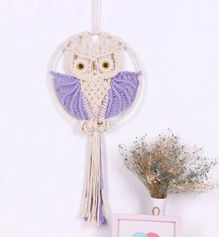 Décoration murale macramé hibou avec plumes violettes, ajout artisanal original pour chambre ou salon, accessoire unique pour une ambiance bohème et chaleureuse.