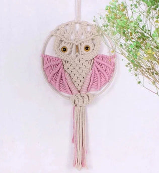 Suspension murale hibou en macramé avec détails roses, parfait pour une décoration bohème et naturelle dans votre intérieur. Fait main, ce capteur de rêves hibou ajoute une touche originale et charmante à votre espace de vie. Idéal pour une chambre d'enfant ou un salon à l'ambiance apaisante. Accessoire déco artisanal et tendance.