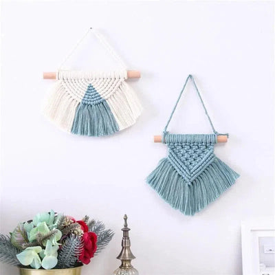Décoration murale bohème avec deux tentures macramé bleu et blanc, idéale pour un intérieur moderne et élégant. Parfait pour ajouter une touche artisanale et tendance à votre salon ou chambre. Plantes décoratives en arrière-plan, créant une ambiance naturelle et apaisante. Accessoires muraux personnalisables, parfaits pour un cadeau original et créatif.