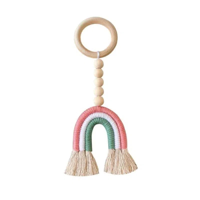 Jouet pour bébé en forme d'arc-en-ciel rose et vert, suspendu à un anneau avec des perles, parfait pour la décoration de la chambre d'enfant ou comme cadeau de naissance.