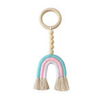 Jouet d'éveil en forme d'arc-en-ciel pastel, suspendu à un anneau avec des perles décoratives. Accessoire idéal pour la chambre de bébé, apportant une touche colorée et apaisante. Cadeau parfait pour stimuler la curiosité des tout-petits.