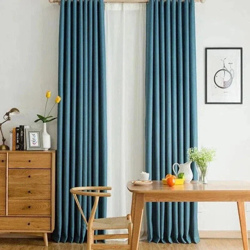 Rideaux bleus élégants pour salon moderne, ajoutant une touche de sophistication à votre intérieur. Associez ces rideaux aux meubles en bois clair pour une ambiance chaleureuse et accueillante. Idéal pour contrôler la lumière tout en améliorant la décoration de votre espace de vie.