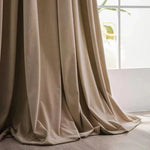 Rideau beige élégant, idéal pour salon moderne, s'harmonise avec tout type de décoration intérieure. Longues draperies tombant gracieusement sur un sol en bois clair. Parfait pour filtrer la lumière naturelle tout en ajoutant une touche de sophistication à votre espace de vie.