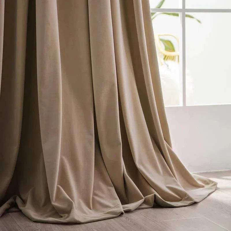 Rideau beige élégant, idéal pour salon moderne, s'harmonise avec tout type de décoration intérieure. Longues draperies tombant gracieusement sur un sol en bois clair. Parfait pour filtrer la lumière naturelle tout en ajoutant une touche de sophistication à votre espace de vie.