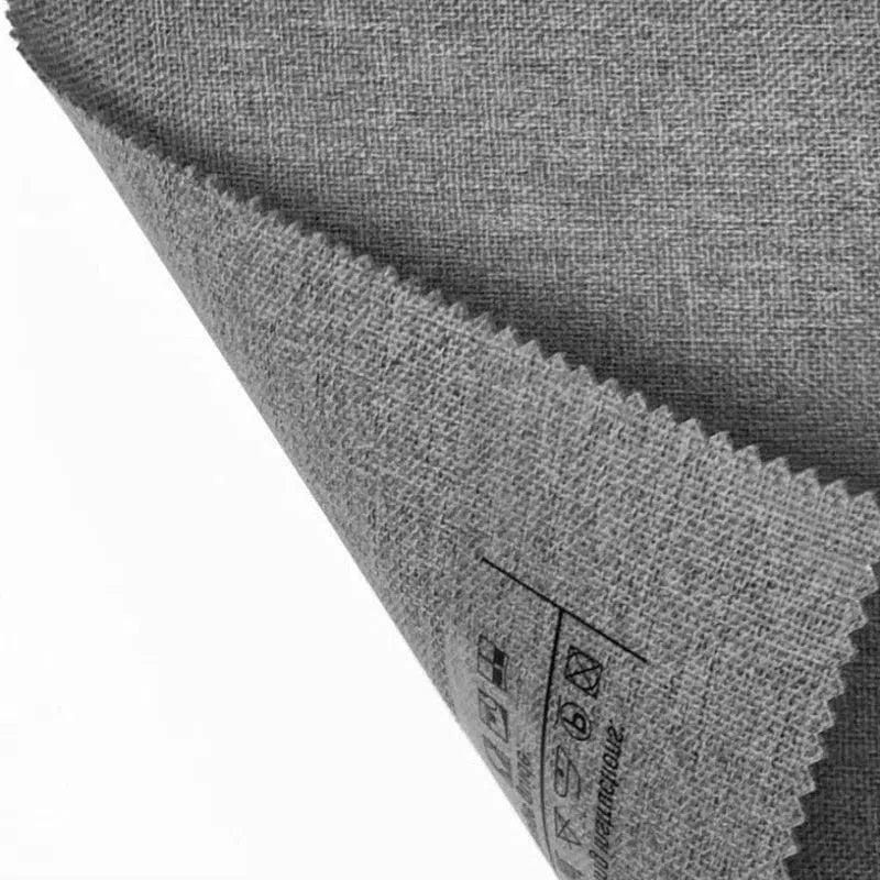 Échantillon de tissu gris avec bordure en zigzag, montrant des symboles d'entretien imprimés, idéal pour la décoration intérieure et le design textile.