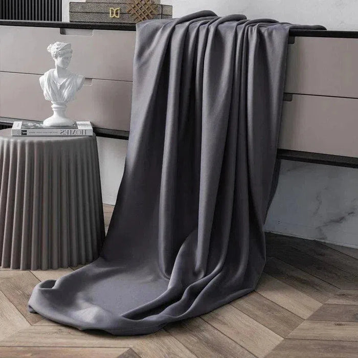 Plaid élégant gris drapé sur une commode moderne, ajoutant une touche sophistiquée à un intérieur chic. Ce jeté polyvalent s'harmonise parfaitement avec la décoration contemporaine et offre un confort optimal pour des moments de relaxation. Parfait pour sublimer votre salon ou chambre.