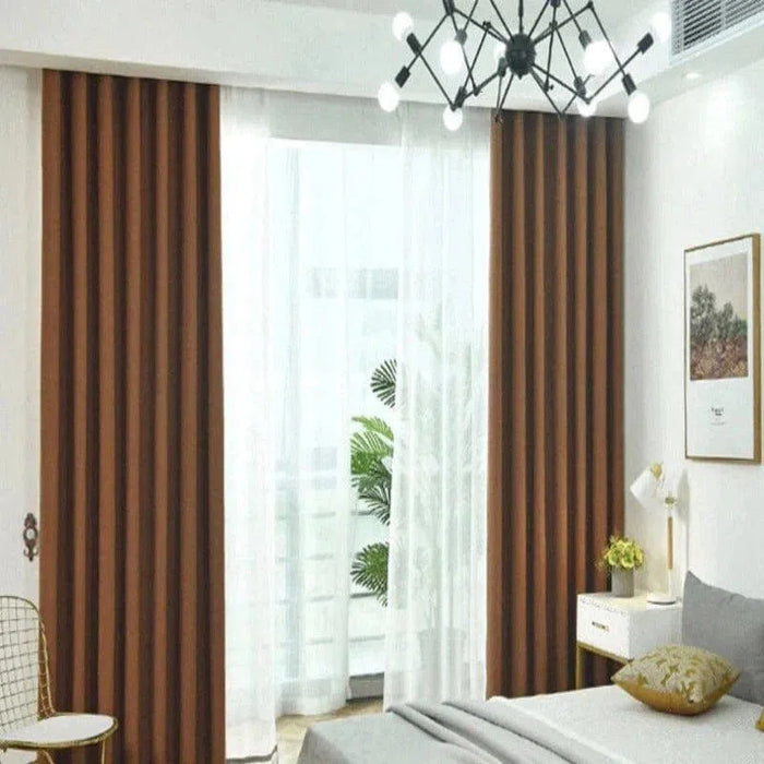 Rideaux marron assortis à une décoration de chambre moderne avec lit gris et lampe design. Fenêtre laissant passer la lumière naturelle pour une ambiance chaleureuse et élégante, mettant en valeur un intérieur contemporain. Idéal pour optimiser l'éclairage et le style de votre espace de vie.