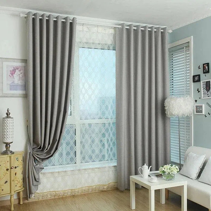 Rideaux opaques gris pour salon avec fenêtre moderne, ornés d'une décoration intérieure élégante comprenant une table basse blanche, un canapé confortable et des accents décoratifs. Solution idéale pour ajouter une touche sophistiquée à votre espace tout en préservant l'intimité et en contrôlant la lumière naturelle. Parfait pour créer une ambiance chaleureuse et contemporaine dans votre maison.