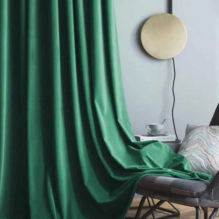 Rideau élégant vert dans un salon moderne avec fauteuil confortable, tasse à café et lampe murale décorative. Parfait pour ajouter une touche de couleur et de sophistication à votre intérieur. Idéal pour le salon ou la chambre, créant une ambiance apaisante et chaleureuse.