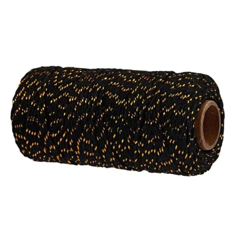 Bobine de fil noir avec motifs dorés pour travaux créatifs et décoratifs. Idéal pour couture, tricot, et projets de décoration intérieure. Accessoire essentiel pour personnalisation et embellissement des textures.