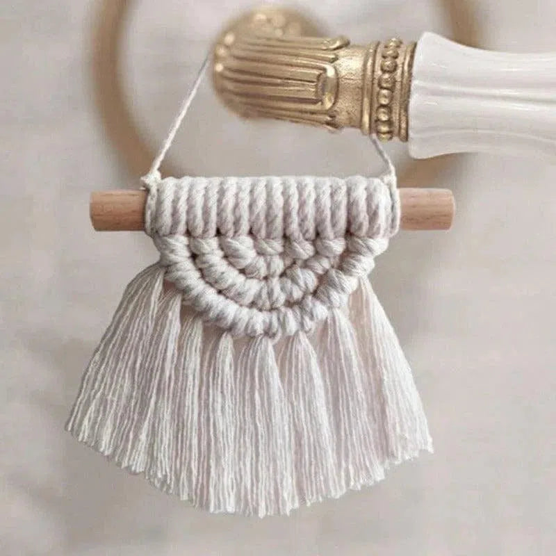 Décoration murale artisanale en macramé, motif demi-cercle avec franges, idéal pour embellir un intérieur bohème. Accessoire élégant s'accrochant facilement sur une poignée de porte pour une touche artistique personnalisée. Objet décoratif tendance recherché pour son style unique et sa capacité à enrichir l'atmosphère d'une pièce.