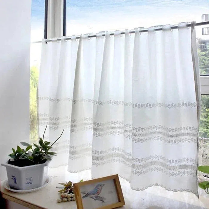 Rideau blanc élégant pour fenêtre, idéal pour une décoration d'intérieur lumineuse et épurée. Ce rideau, présenté dans une pièce avec vue sur la nature, apporte une ambiance sereine et accueillante. Parfait pour embellir votre salon ou votre chambre, tout en laissant passer la lumière naturelle.