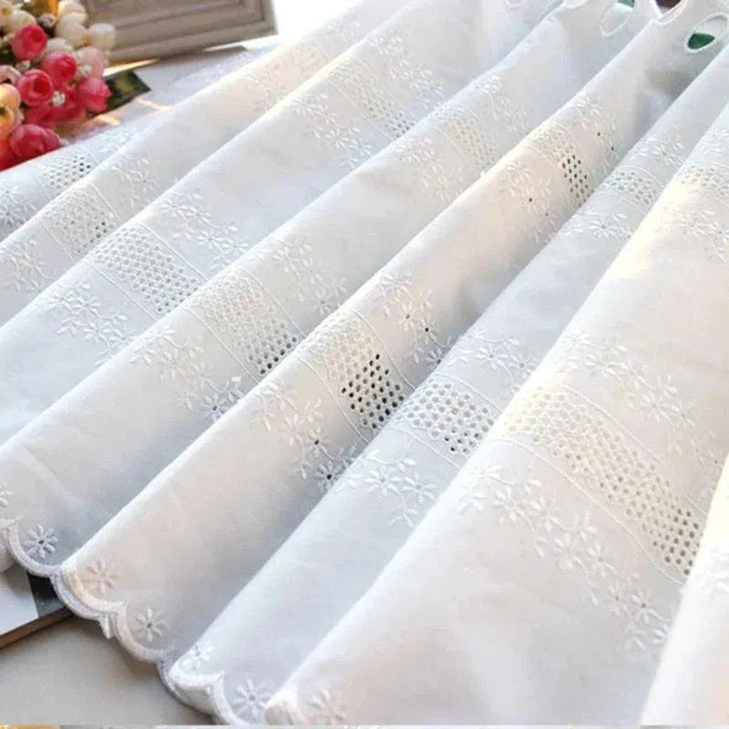 Voilage blanc brodé élégant avec motifs floraux ajourés, idéal pour la décoration intérieure. Parfait pour filtrer délicatement la lumière tout en apportant une touche raffinée à votre salon ou chambre. Accessoire de maison tendance et chic pour embellir vos fenêtres.