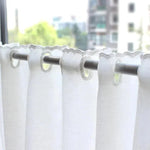Rideaux blancs élégants pour la décoration intérieure, parfaits pour ajouter une touche de modernité et de sobriété à votre maison. Idéaux pour une ambiance lumineuse et épurée, ces rideaux sont accrochés à une tringle métallique, soulignant leur tombé fluide et raffiné. Accessoire déco essentiel pour sublimer vos fenêtres et créer un espace harmonieux.