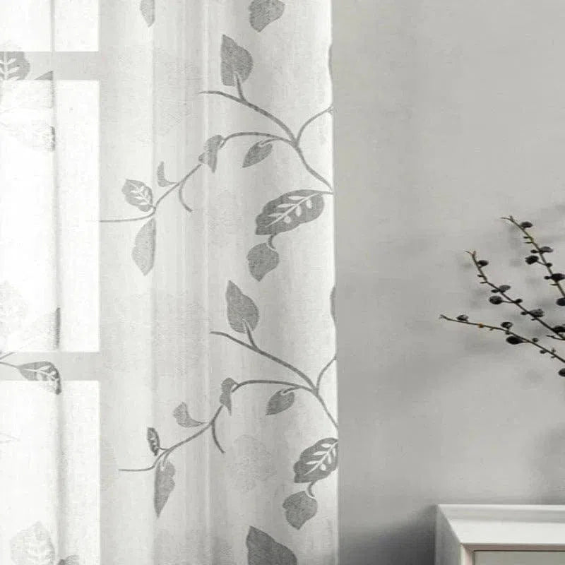 Voilage élégant avec motif de feuilles grises pour une décoration intérieure raffinée, idéal pour salon ou chambre, apportant une touche de nature et de lumière douce à votre espace de vie.