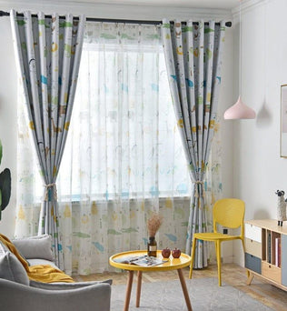 Chambre lumineuse avec grande fenêtre ornée de rideaux à motifs animaliers, entourée d'un décor moderne. La pièce comprend un canapé gris, une table d'appoint jaune et un abat-jour rose. Atmosphère chaleureuse et conviviale idéale pour un salon moderne.