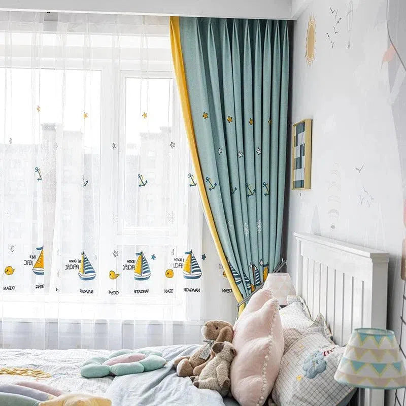 Chambre d'enfant décorée avec élégance, mettant en valeur des rideaux à motif nautique bleu et blanc, parfaits pour créer une ambiance apaisante. Ce design est idéal pour inspirer l'imaginaire des petits aventuriers et apporter une touche ludique à la pièce. Ambiance lumineuse et joyeuse accentuée par des accessoires tendres comme des peluches et des coussins. Parfait pour une décoration de chambre moderne et enfantine.
