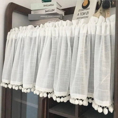 Rideau blanc court avec pompons décoratifs, idéal pour ajouter une touche élégante à votre intérieur tout en préservant l'intimité. Parfait pour les cuisines, salles de bains ou petites fenêtres. Accessoire décoratif et fonctionnel pour sublimer votre décoration intérieure.