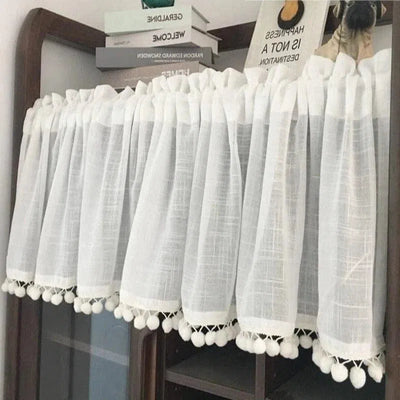 Rideau blanc court avec pompons décoratifs, idéal pour ajouter une touche élégante à votre intérieur tout en préservant l'intimité. Parfait pour les cuisines, salles de bains ou petites fenêtres. Accessoire décoratif et fonctionnel pour sublimer votre décoration intérieure.