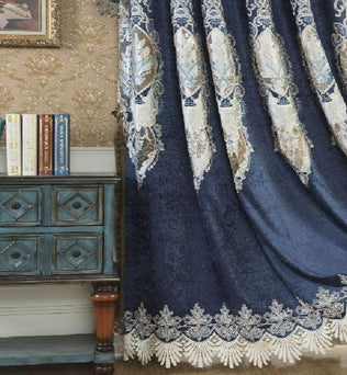 Rideau élégant avec motifs baroques en bleu et blanc, offrant une touche luxueuse à votre intérieur. Parfait pour sublimer n'importe quelle pièce de vie. Accompagné d'une commode vintage et d'une décoration murale sophistiquée, cet ensemble apporte une ambiance raffinée à votre espace. Ideal pour embellir votre salon ou chambre avec style.