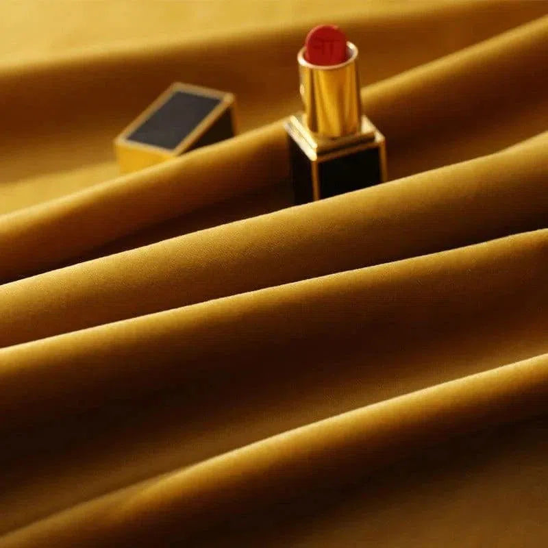 Rouge à lèvres luxueux sur fond drapé doré, élégant et sophistiqué, parfait pour une touche glamour dans votre routine beauté quotidienne.