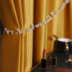 Rideau élégant de couleur dorée rehaussé d'une attache ornée de perles translucides, parfait pour ajouter une touche sophistiquée à votre intérieur. Idéal pour les salons modernes cherchant à allier esthétisme et fonctionnalité. Apportez une ambiance chaleureuse et chic à votre pièce avec cet accessoire de décoration raffiné.