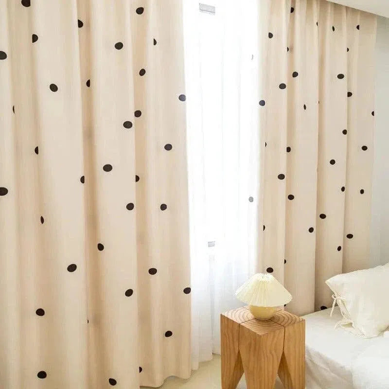 Rideaux élégants avec motifs à pois noirs dans une chambre lumineuse. Ces rideaux modernes ajoutent une touche de déco chic et contemporaine à votre intérieur. Parfaits pour filtrer la lumière, ils créent une ambiance chaleureuse et cosy dans la pièce. Idéals pour une chambre à coucher ou un salon recherchant un style à la fois minimaliste et tendance.